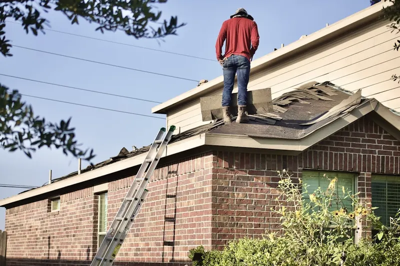 Professional roofer working on a residential roof in The South Forty